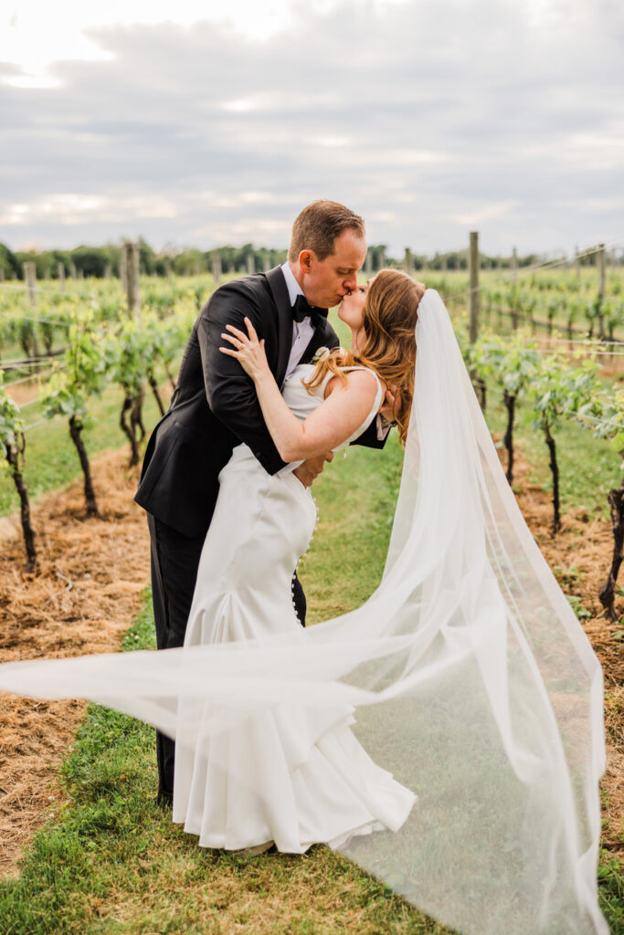 Newlyweds kiss among vines at Bedell Cellars
